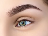 Close up view of beautiful green female eye. Perfect trendy eyebrow. Good vision, contact lenses, brow bar or fashion eyebrow makeup concept